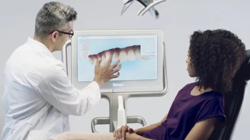 A dentist reviewing a digital scan of teeth with a patient