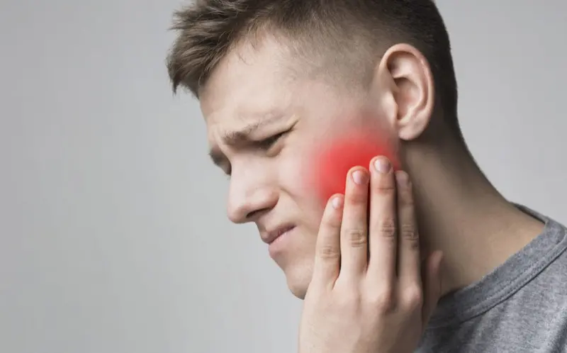 Patient holding their jaw with tooth pain